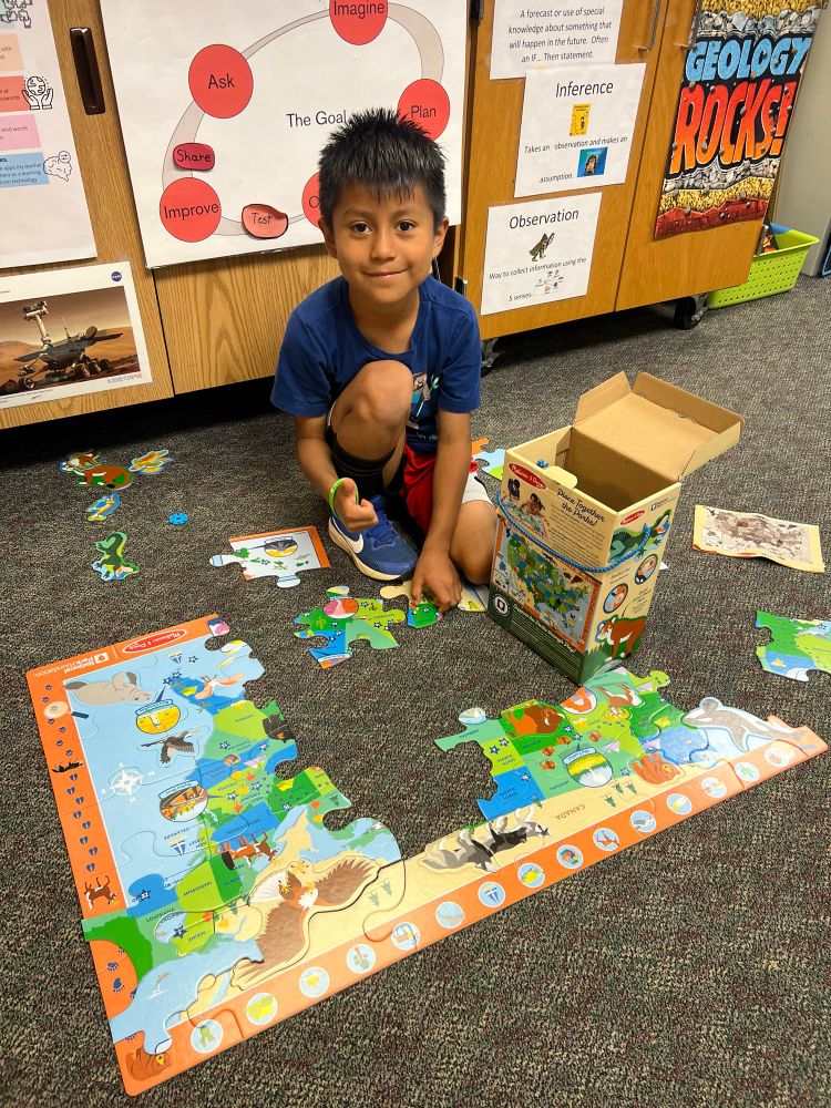 student on the carpet working on an endangered animals puzzle