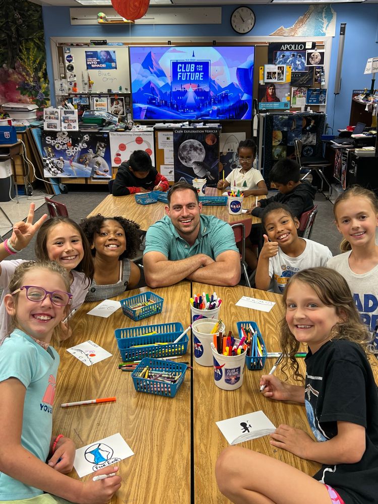 Mr. Hunter at table w 3rd grade students 