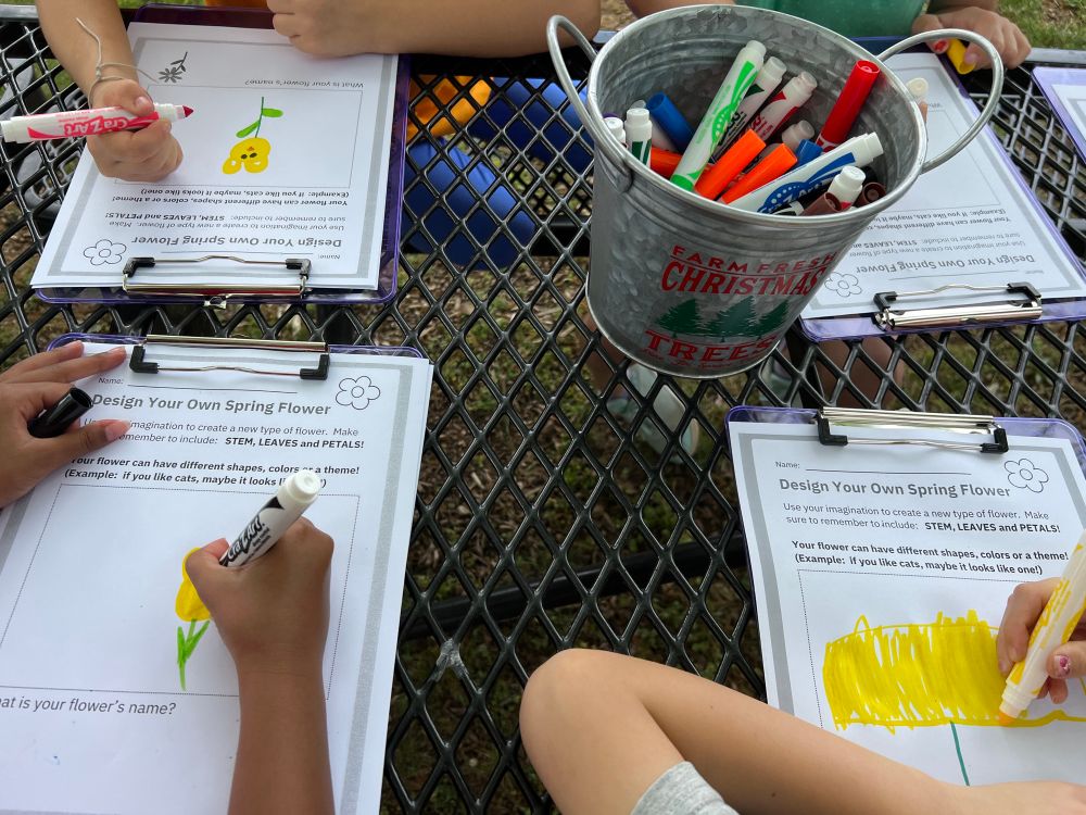 Students use markers to design their own spring flower 