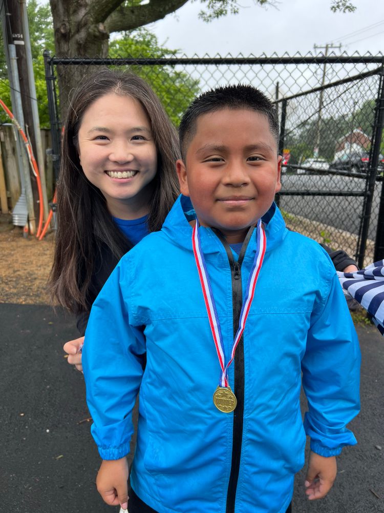 Principal Han with one of the Barrett Runners wearing a medal