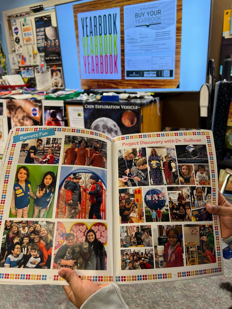 Holding a yearbook from a past year. 