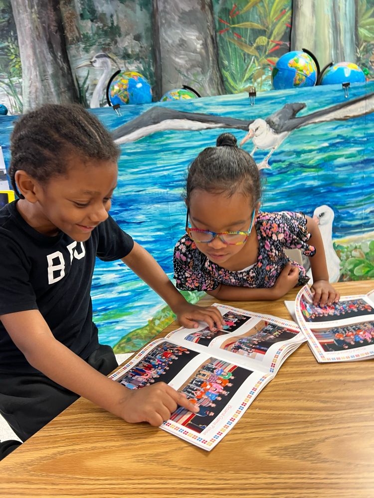 Students point at yearbook somebody they know. 