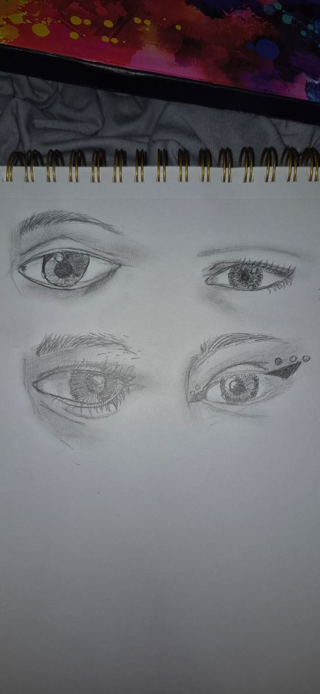 A sketch page with 4 different eyes drawn on it 
