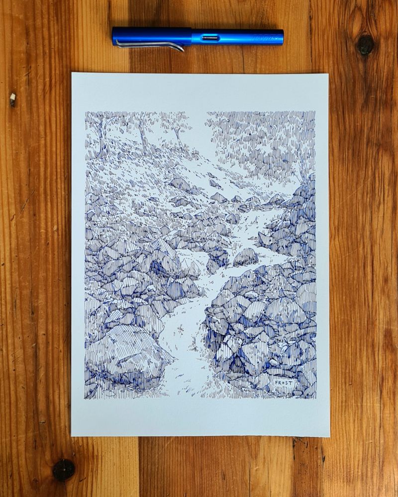 A photo of a fountain pen & an original drawing on A4 white cartridge paper, portrait in orientation. The drawing depicts a river running over rocks. The drawing is monochrome blue and created with a fountain pen line hatching shading technique 