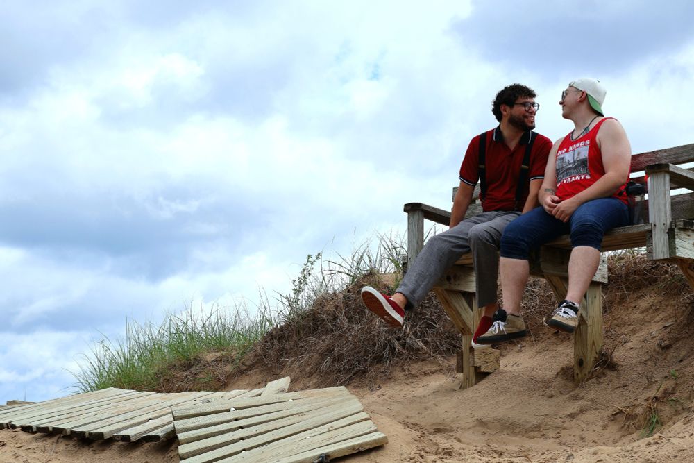 A picture of Alec and me and sitting on a bench against a blue sky.