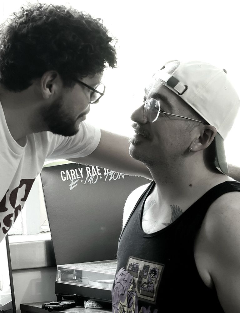 A grayscale picture of me leaning over to a sitting Alec and we're both looking into each other's eyes.