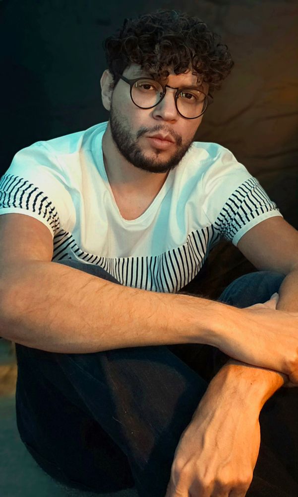 Picture of me sitting on the floor. I'm wearing jeans and a white t-shirt with stripes and my hair looks okay for once.