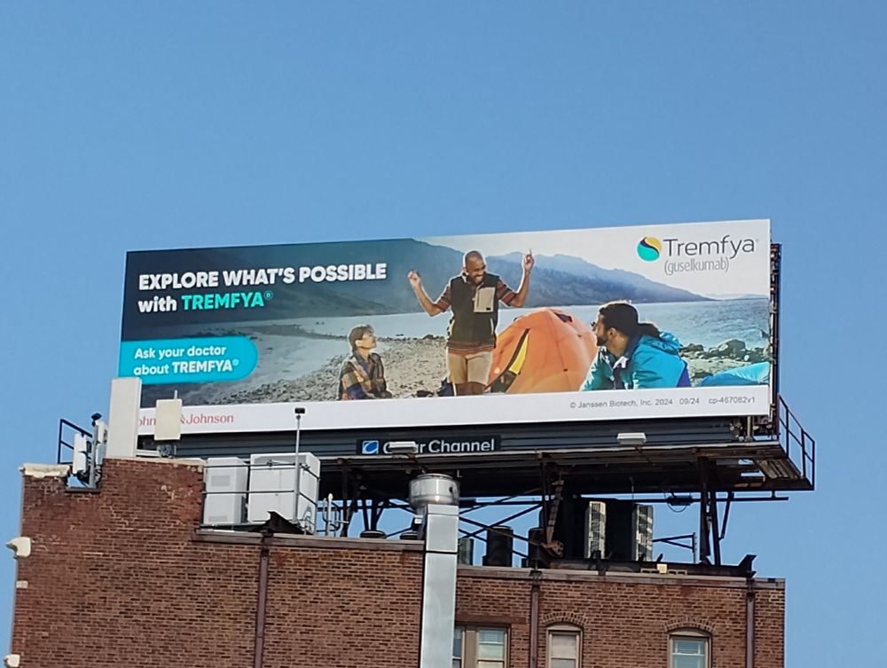 a billboard for TREMFYA with a picture of some people camping. it does not say what the drug does