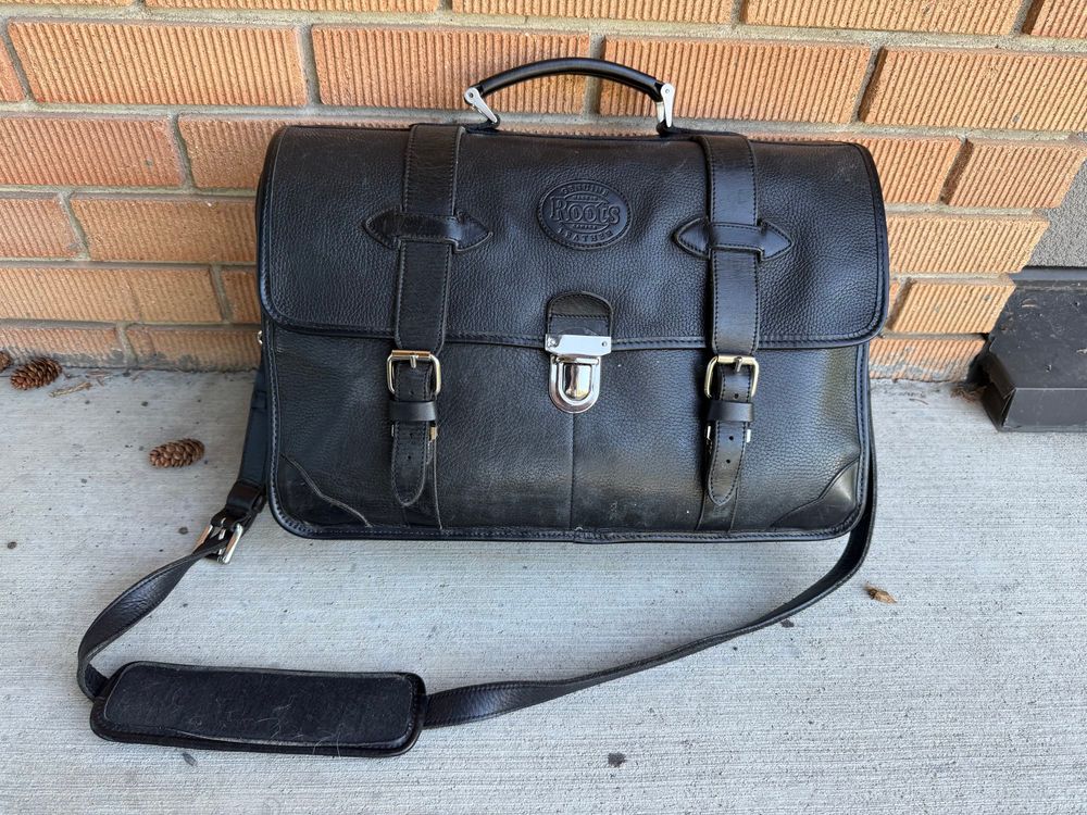 Black leather flap-type soft briefcase/bag with silver straps and buckles. It shows signs of having been loving used for decades.