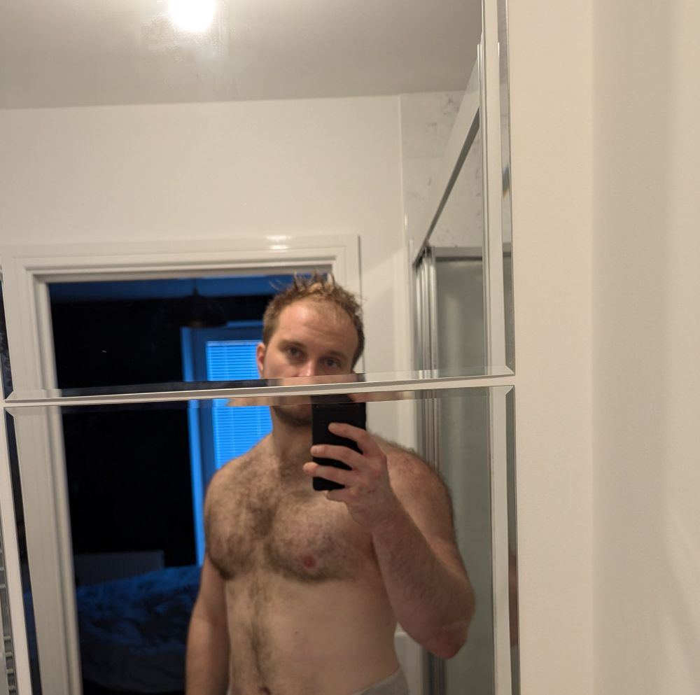 Shirtless photo of a man in a towel in a bathroom