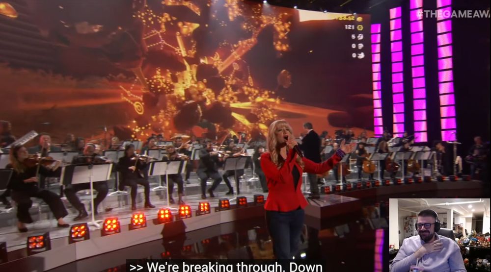 Bridge watching the Donkey Kong Bananza portion of the 2025 Game Awards Game of the Year orchestral medley. Jenny Kidd (Paulline's VA) is on stage performing the song and Bridge is staring happily on camera. 