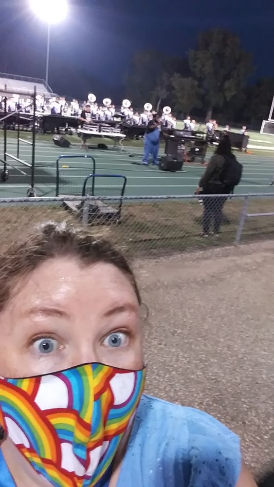Woman in a mask field side for a performance. 