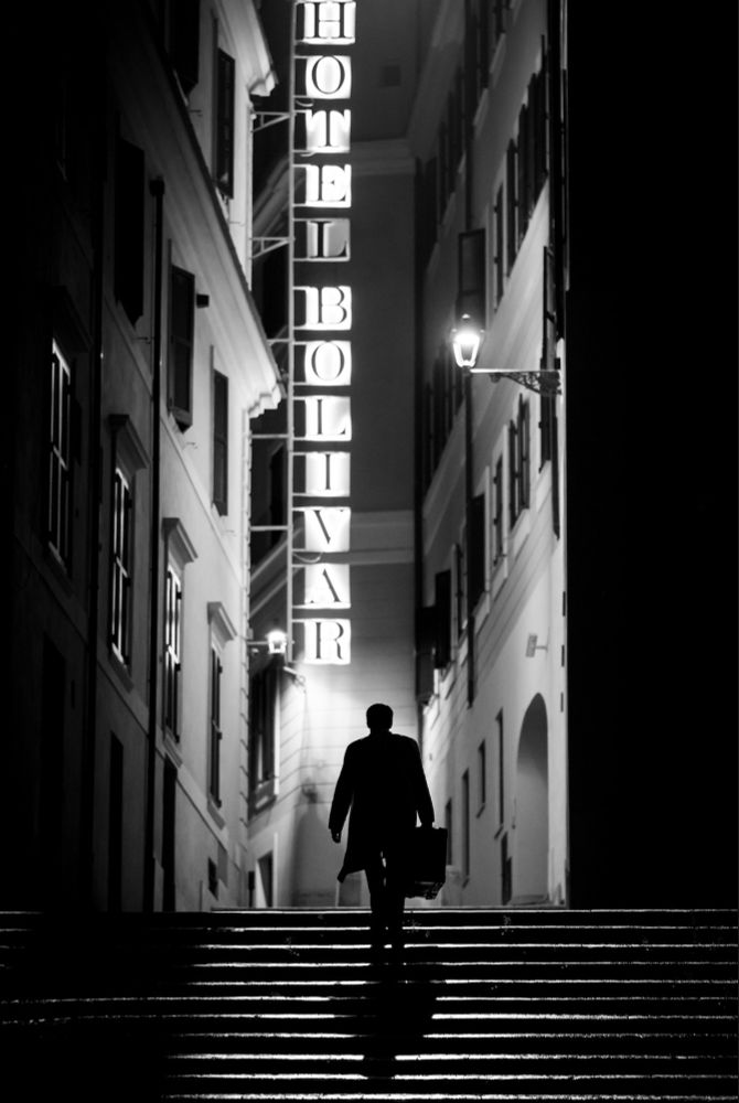 another shot from Zaillian's Ripley adaptation, this one of Tom entering an alley at night, the narrow walls illuminated by the decaying hotel marquee
