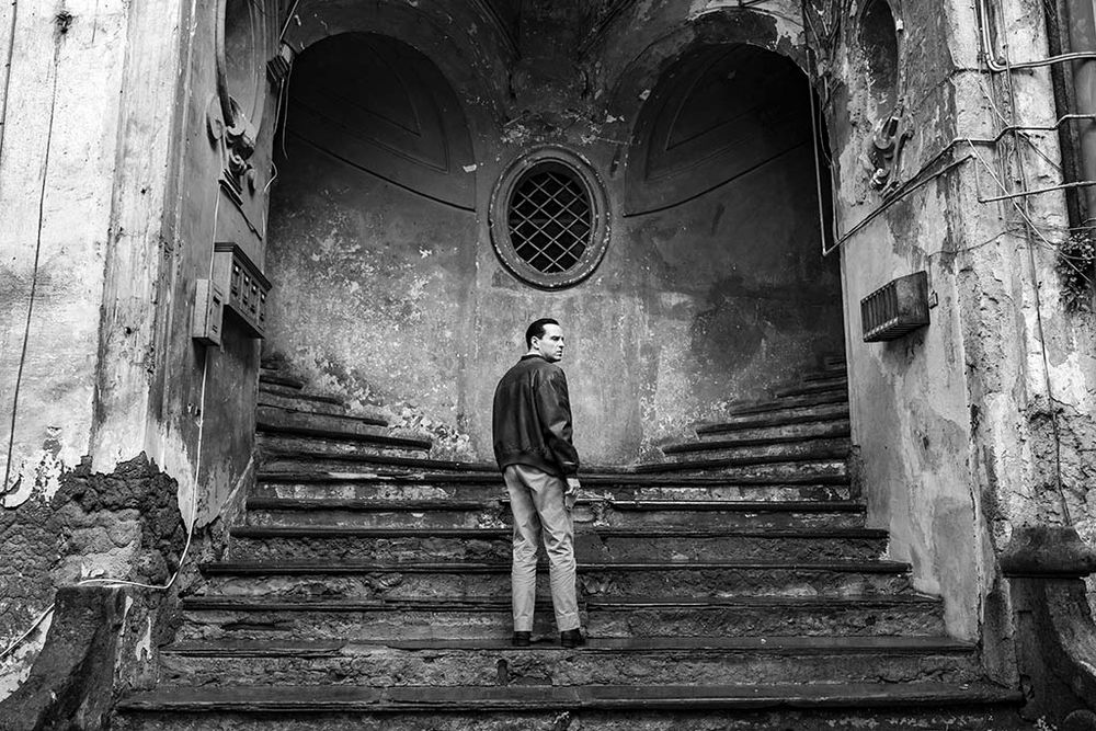 a shot from Zaillian's Ripley adaptation, with Tom perched indecisively at a branch on a split and crumbling staircase in Italy
