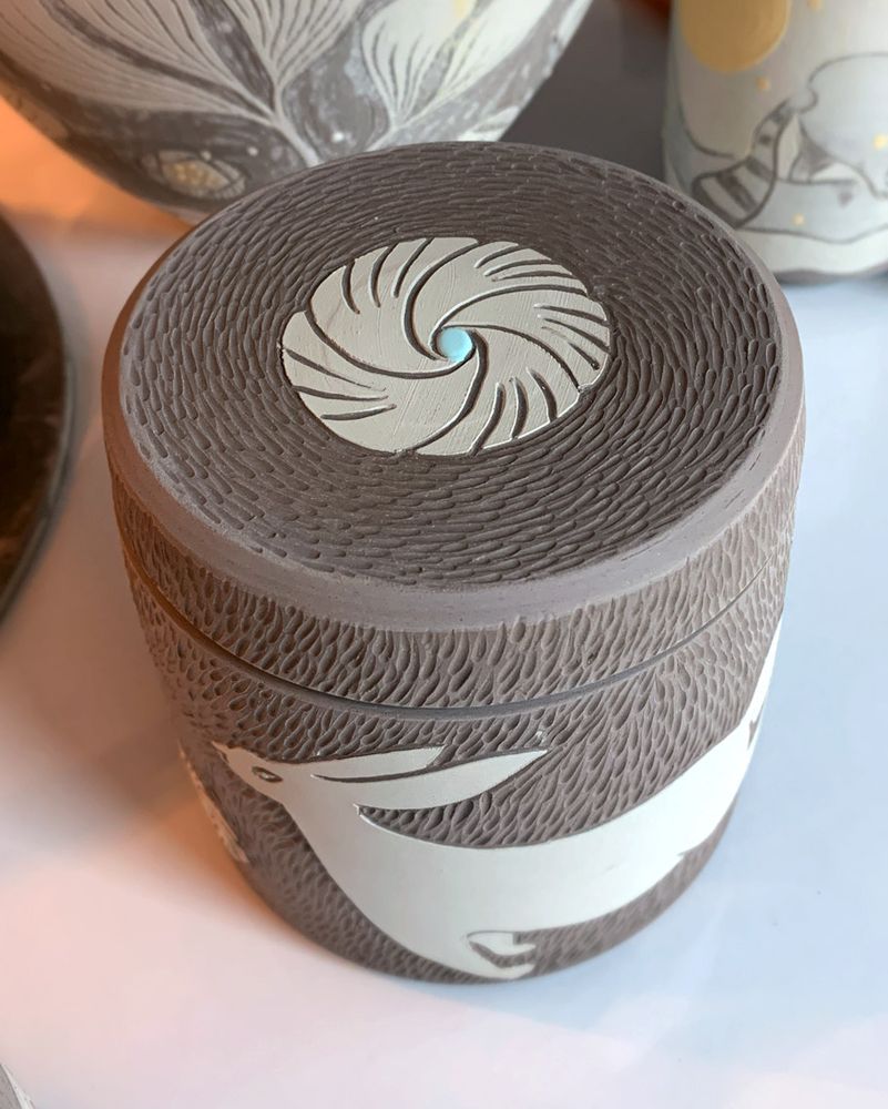 White hare and flowers on a handmade lidded jar.