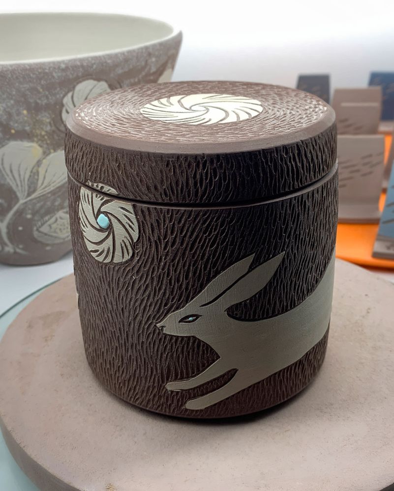 Running white hare on a wheelthrown lidded jar.