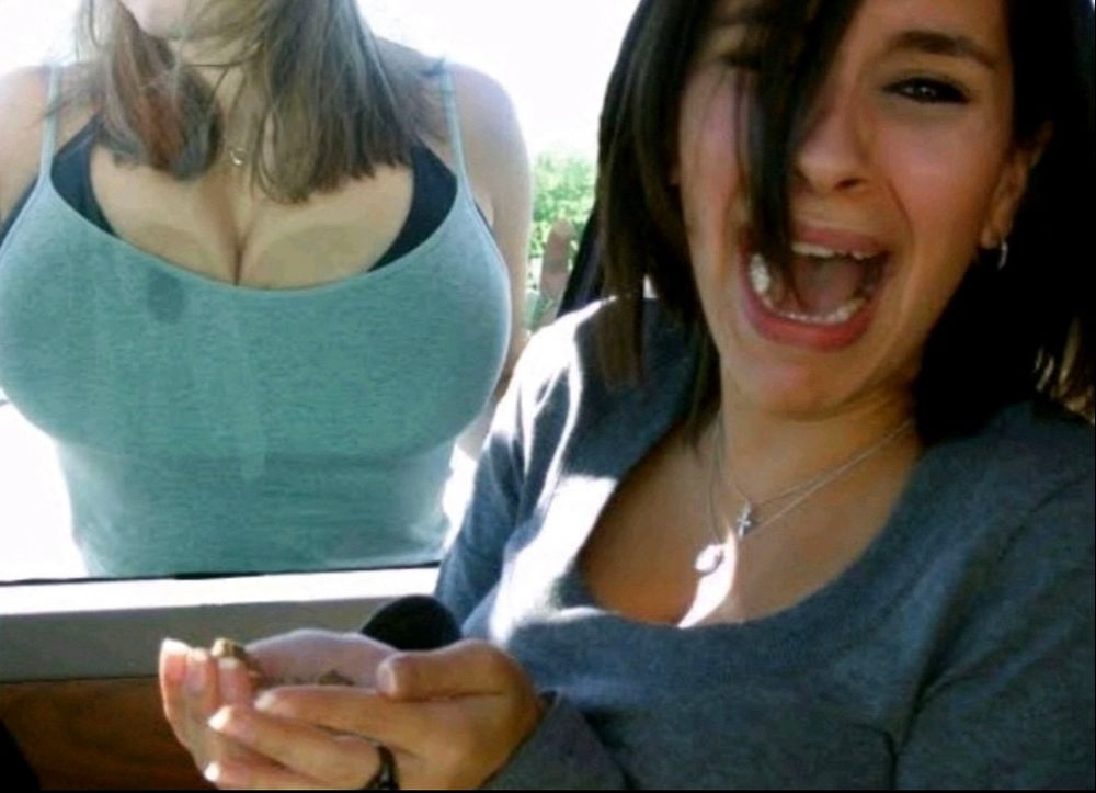 Woman crying in car with another woman in a tank top’s breasts pressed into the window