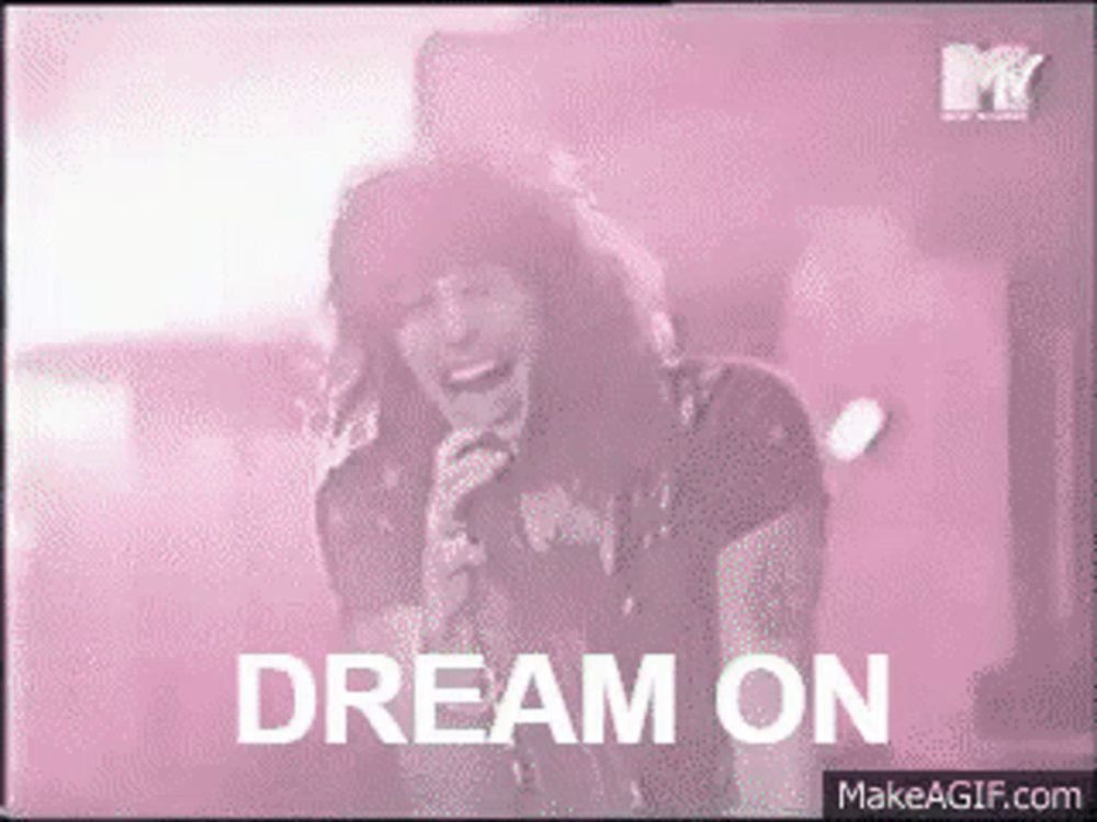 a woman singing into a microphone with the words " dream on " behind her