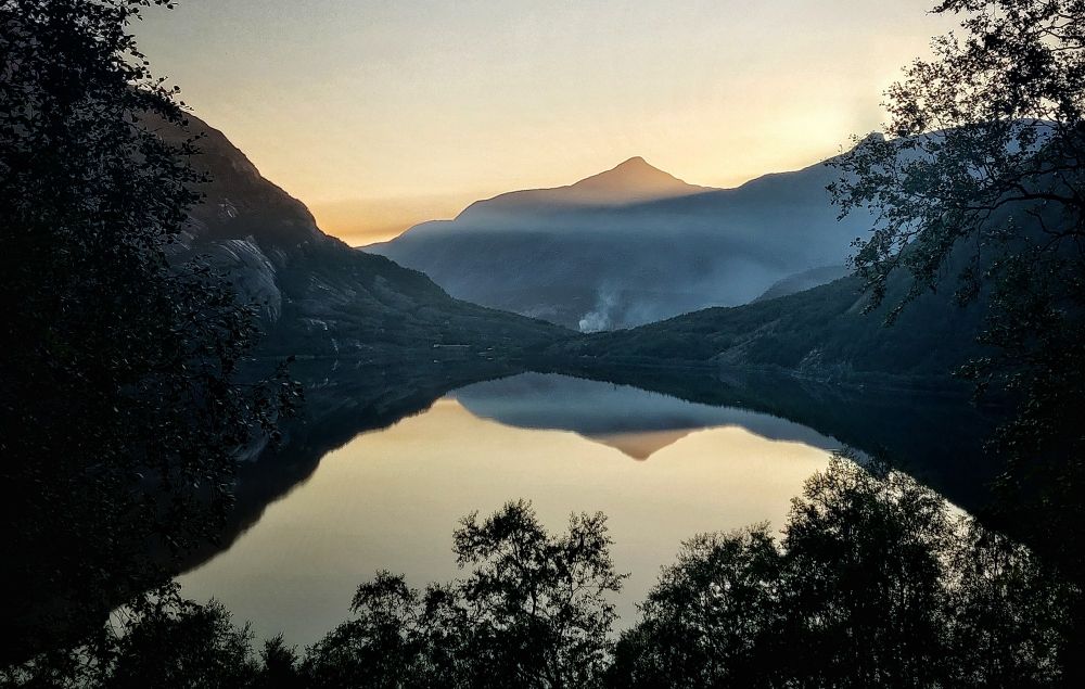 Berg spiegelt sich in einem See in der Dämmerung, norwegisches Setting