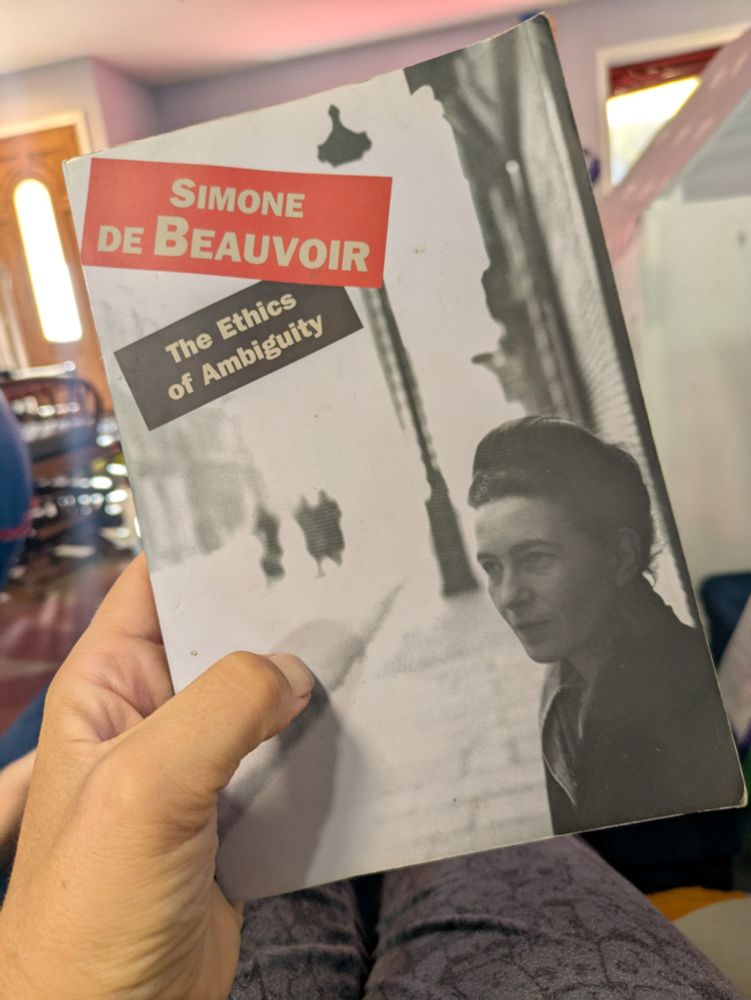 Photo of my hand holding the book "The Ethics of Ambiguity" by Simone de Beauvoir