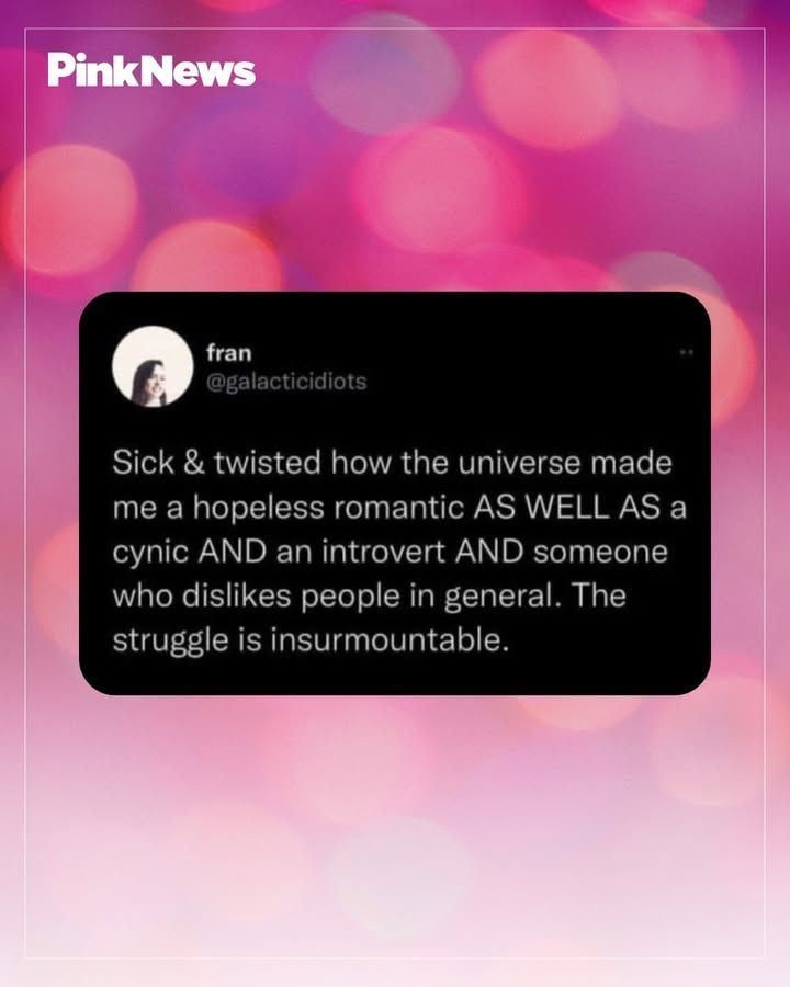 A PinkNews graphic featuring a tweet by @galacticidiots expressing humorous frustration about personal traits, including being a romantic, a cynic, an introvert, and disliking people in general, set against a pink bokeh background.