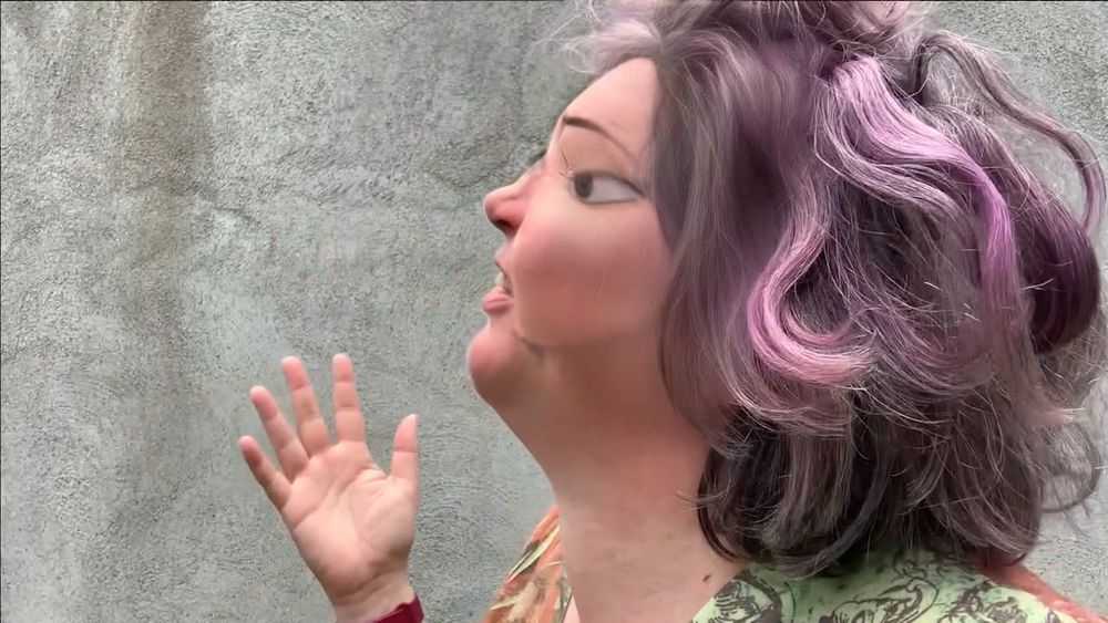Profile of Dayna McLeod with a cartoon filter melting off of her face. She is looking up at something we can't see and has her had out in a questioning gesture.