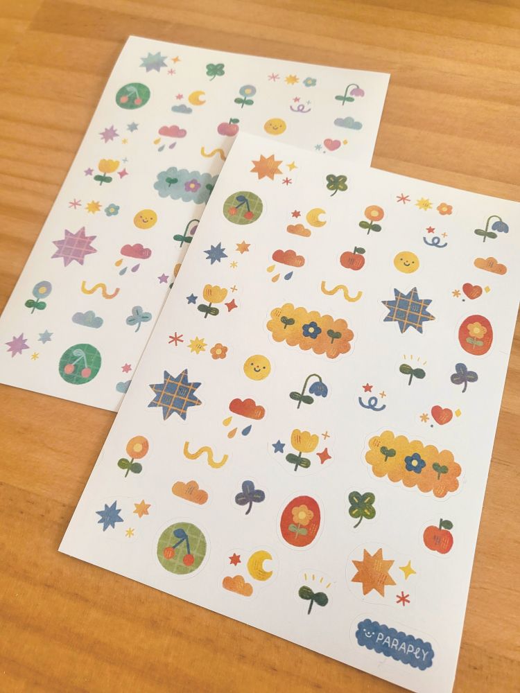 picture of two sticker sheets with various small floral and other decorative elements, one with a warmer and one with a more pastel palette