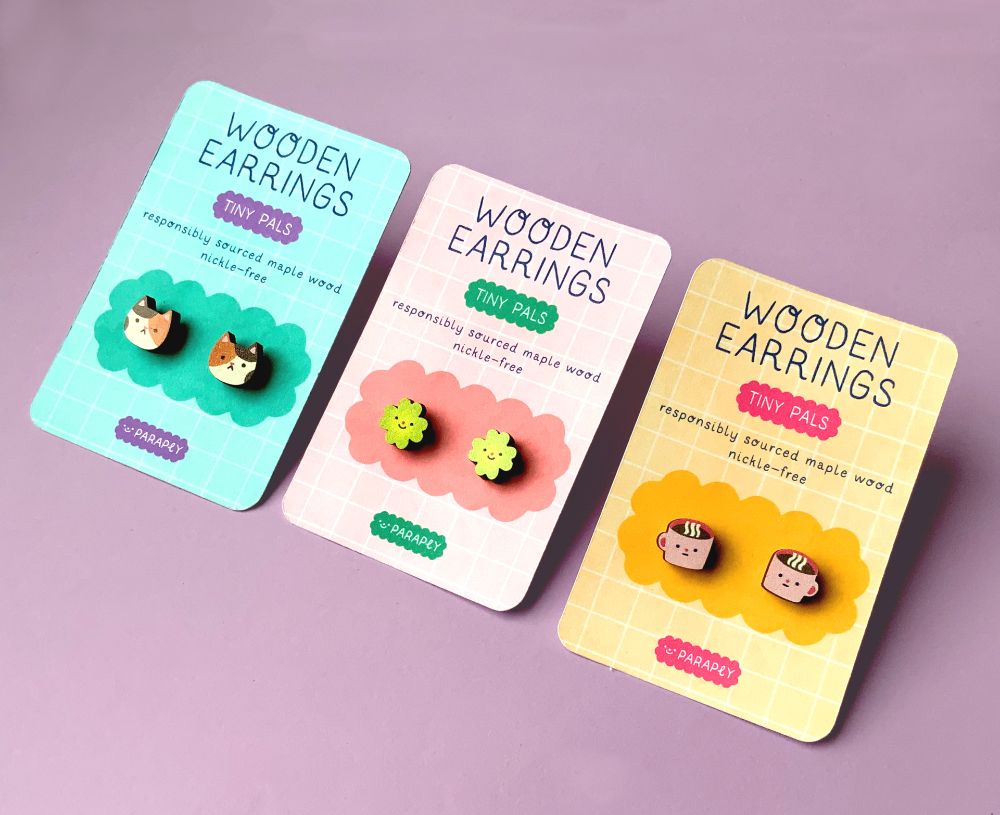 three pairs of wooden earrings: cats, clovers and mugs