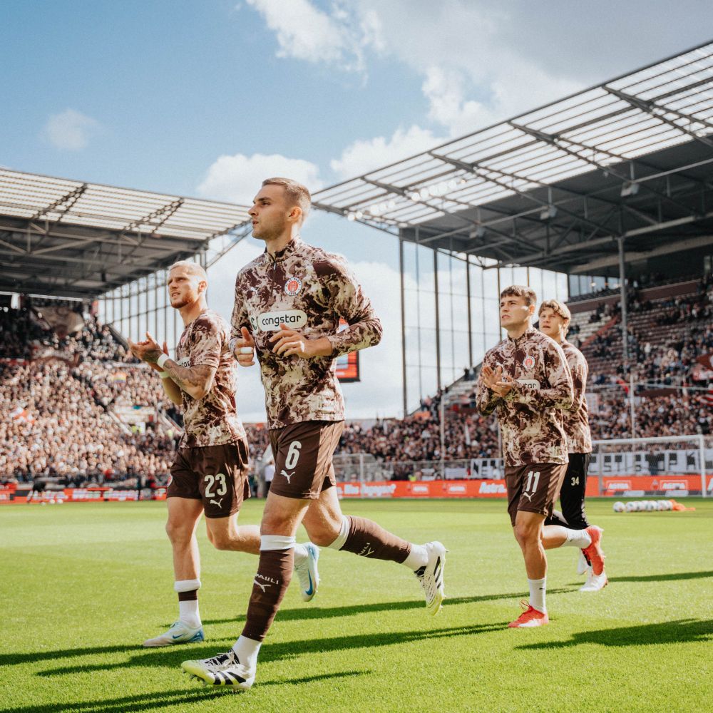 Spieler des FC St. Pauli laufen auf dem Rasen des Millerntor-Stadions