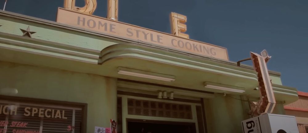 screenshot from na na na by my chem of an old route 66 diner where the N and R are missing