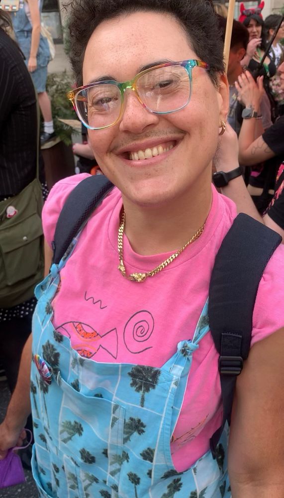 Disco at a trans pride march wearing pink and blue clothing