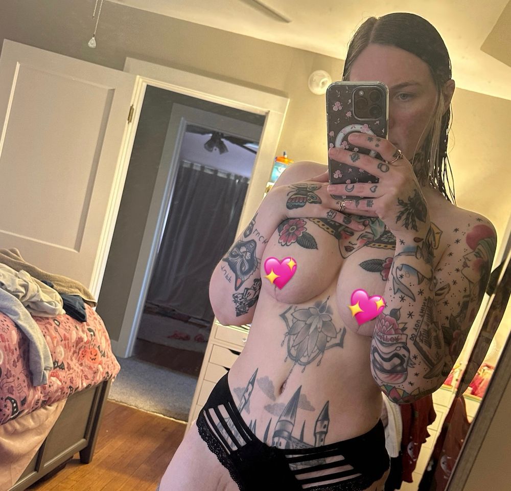 Woman wearing black underwear with heart emojis over the nipples to show postop breast augmentation and tummy tuck surgery results 