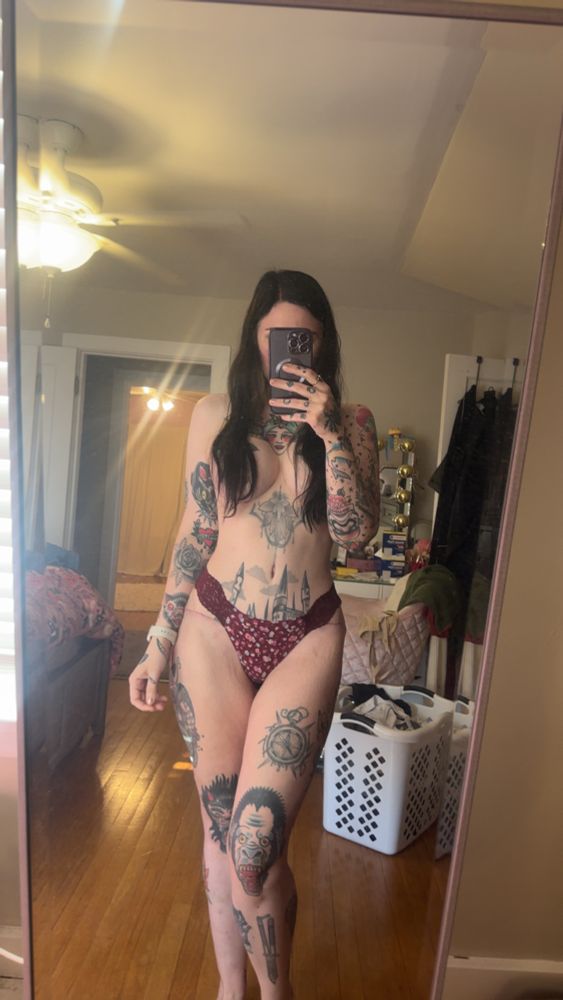 Woman wearing maroon floral underwear with hair covering the nipples to show postop breast augmentation and tummy tuck surgery results 