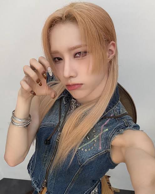 Rui with his long blond hair, wearing a sleeveless denim vest.