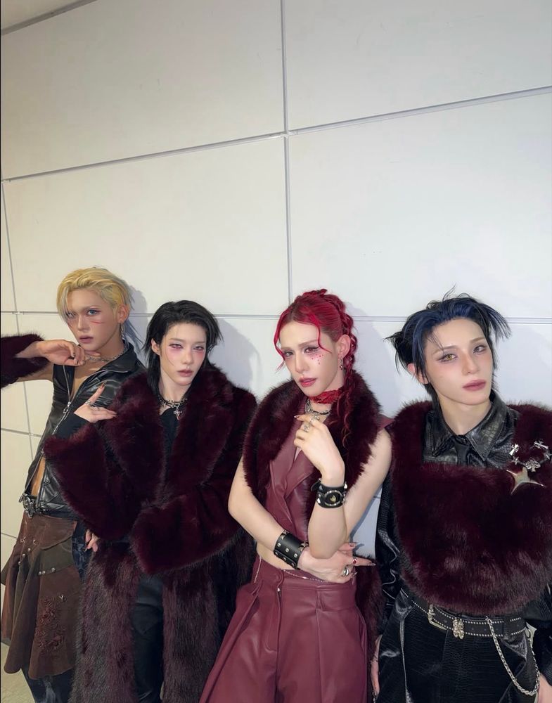 A group photo of xlov. They’re dressed in shades of burgundy and black.