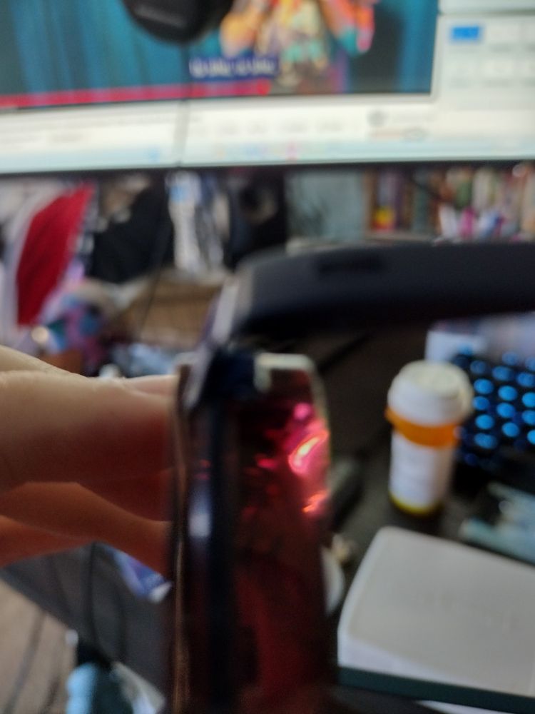 A pair of glasses from a side angle that show off the thickness of the glass, being almost an inch thick. The glass itself is rose tinted.