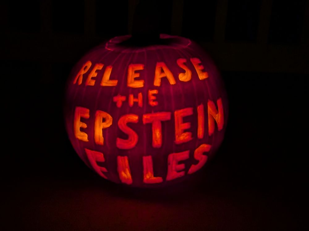 A lit jack o'lantern displaying: Release the Epstein Files 