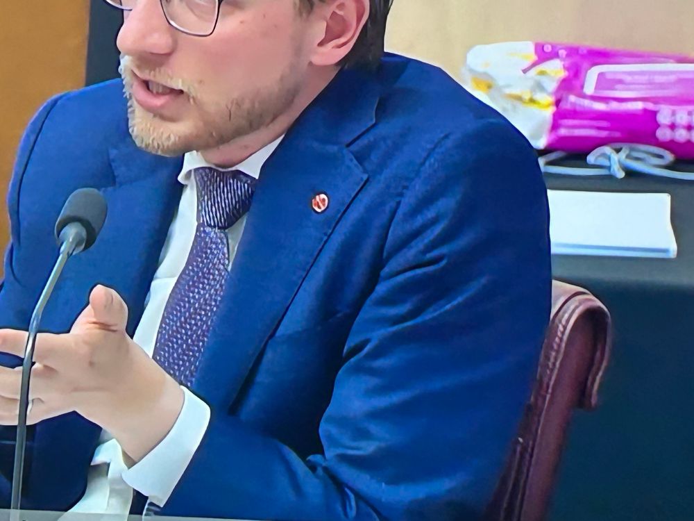 Senator Paterson in Senate Estimates today wearing a blue seat with a red pin on it. 