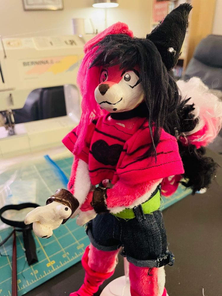 same doll but dressed up in his signature outfit now a cropped striped pink shirt and cutoff shorts