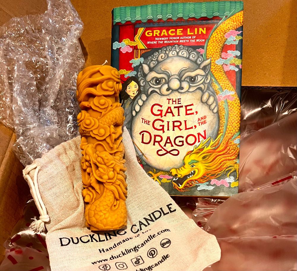 Homemade candle + the book “The Gate, the Girl, and the Dragon”