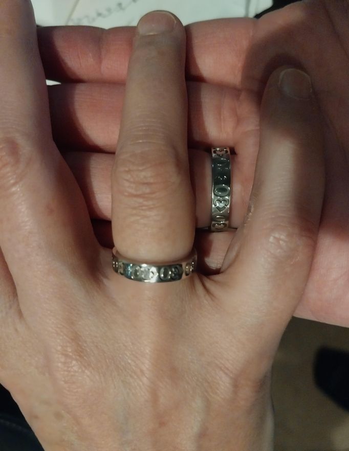 Two hands overlapping, each wearing a ring with <30<30<30<30 engraved around the edge, shaped so the <3 forms a proper heart shape.