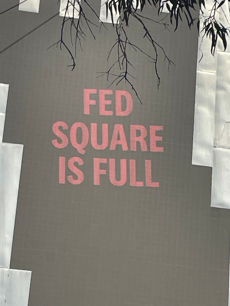 Black screen with bold red font at Fed Square reads “FED SQUARE IS FULL”