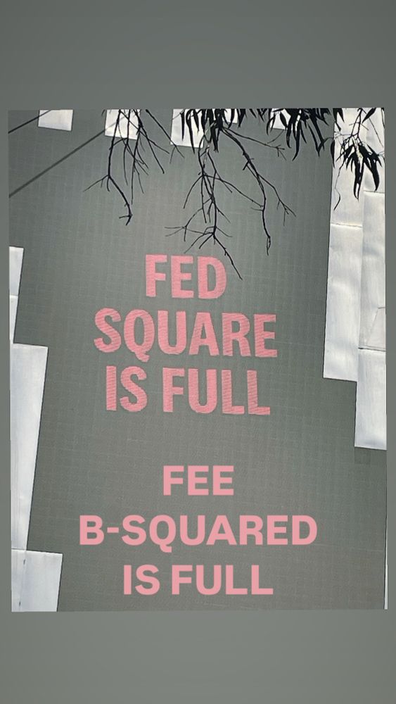 Fee has altered black screen with bold red font at Fed Square to read “FED SQUARE IS FULL FEE B-SQUARED IS FULL”
