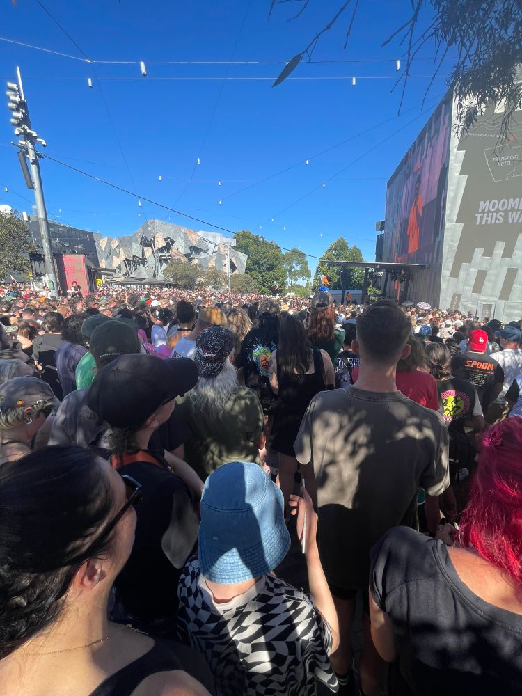 Massive crowd under clear blue skies at Fed Square to see Kneecap.
