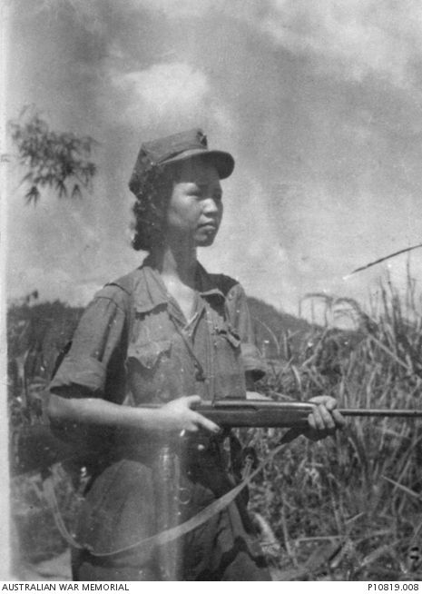 Lee Meng (aka Lee Min), leader of local communist group “Kepayang Gang” in 1951, photographed outdoors, holding a rifle, garbed in international communist fatigues. 