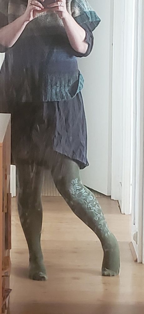 Photo de moi dans le miroir portant la tenue sus mentionnée, on voit les motifs du collant un peu brillant dans la lumière 