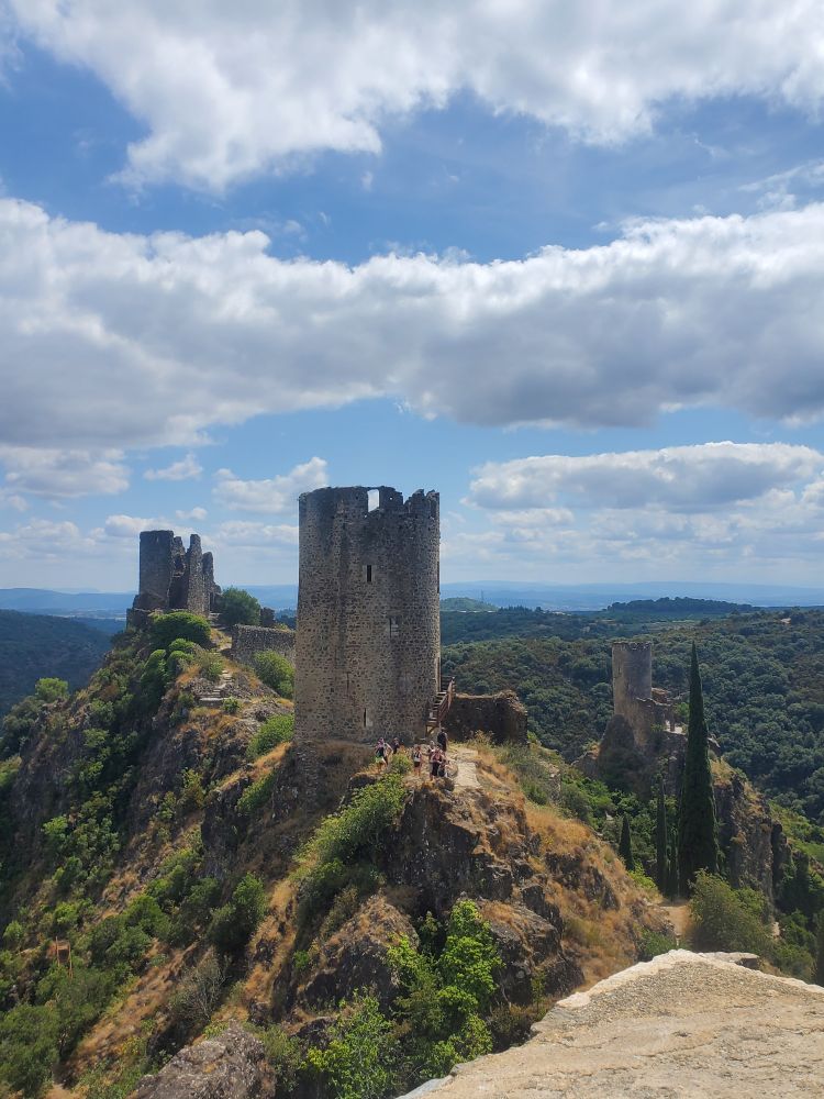 Photo de 2 châteaux du moyen-âge en partie en ruine, dont il reste 2 tours dressées sur une crête de montagne avec un paysage dégagé autour, on aperçoit sur la droite un troisième château