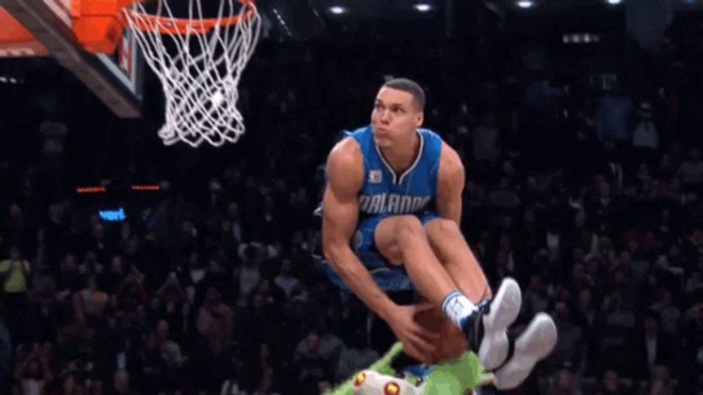 a basketball player for the orlando magic jumps in the air to dunk the ball