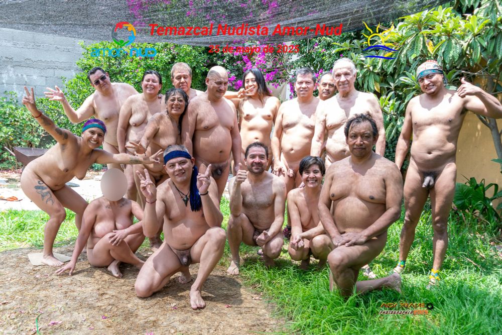 Sixteen nude people on a lawn, in various poses.  The image has the Amor-Nud logo and the Naturist Symbol, and the legends "Amor-Nud Nudist Temazcal" and "May 25, 2025."