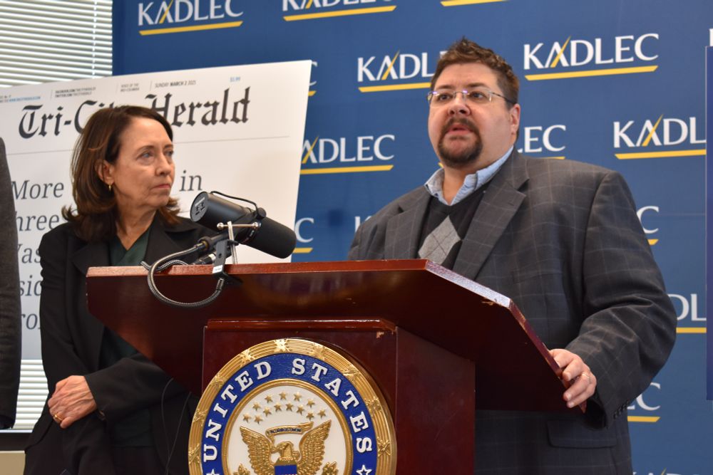 A blue Kadlec hospital sign in the background behind Senator Maria Cantwell and me at a podium talking about the need to keep our health safety net in place.